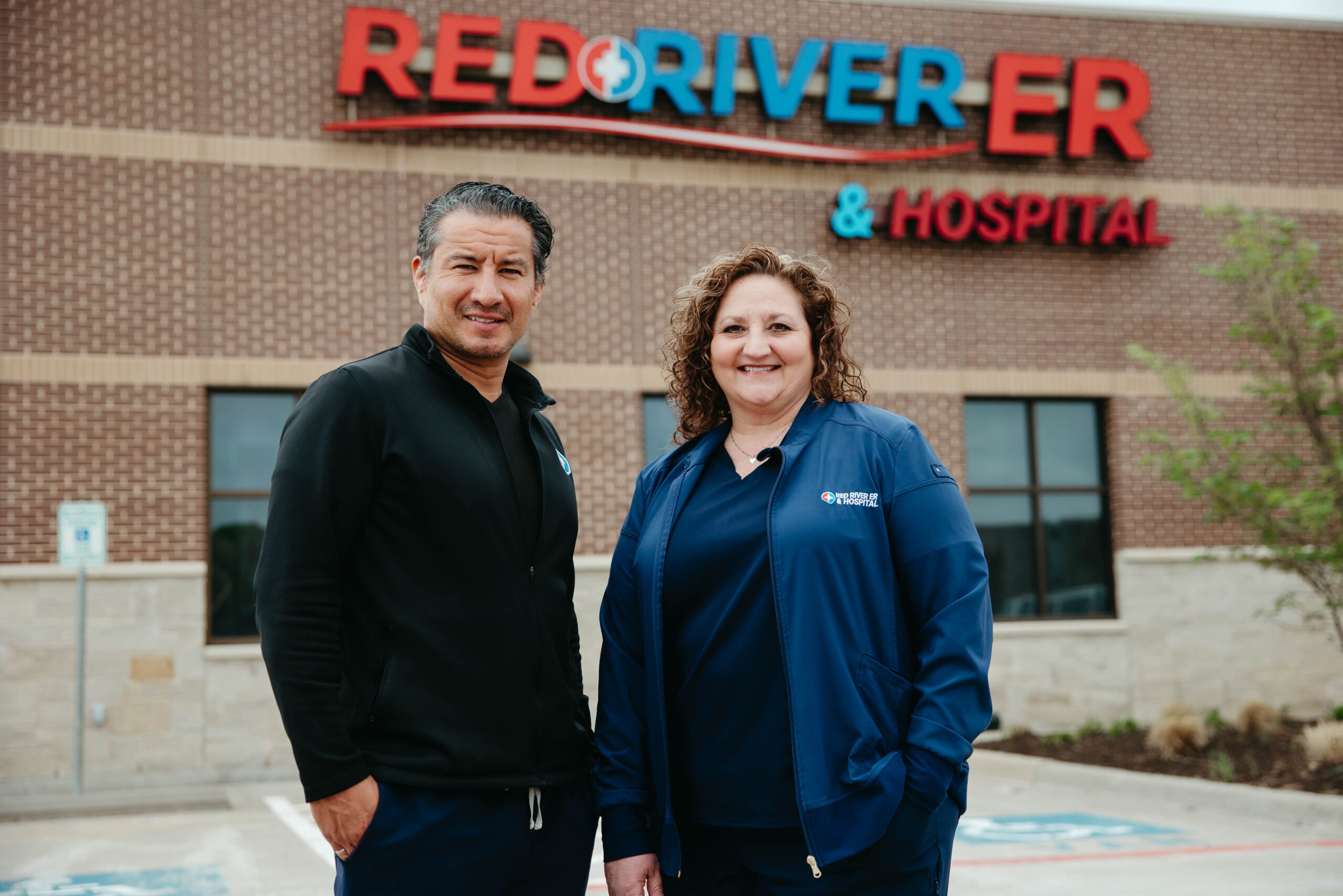 Two staff members of Red River ER & Hospital smiling at the camera.